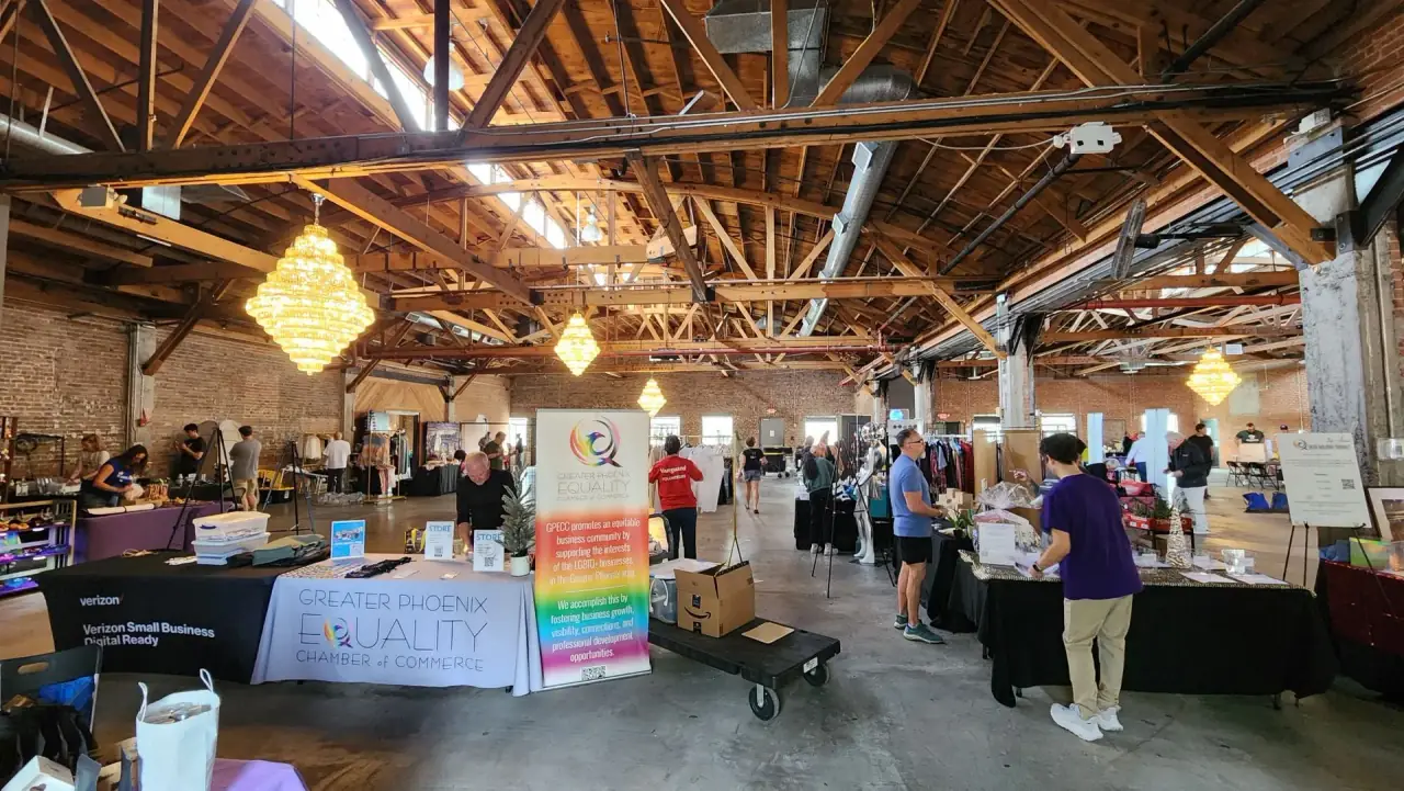 Greater Phoenix Equality Chamber booth welcoming market attendees among vendor stalls